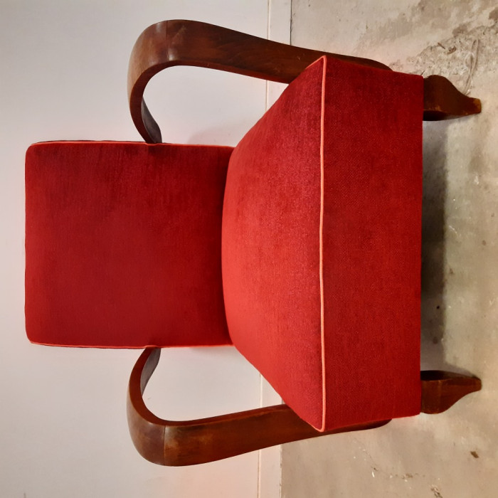 Fauteuil studio bridge vintage des années 50 retapissé avec un tissu velours rouge souligné par un passepoil rose orange